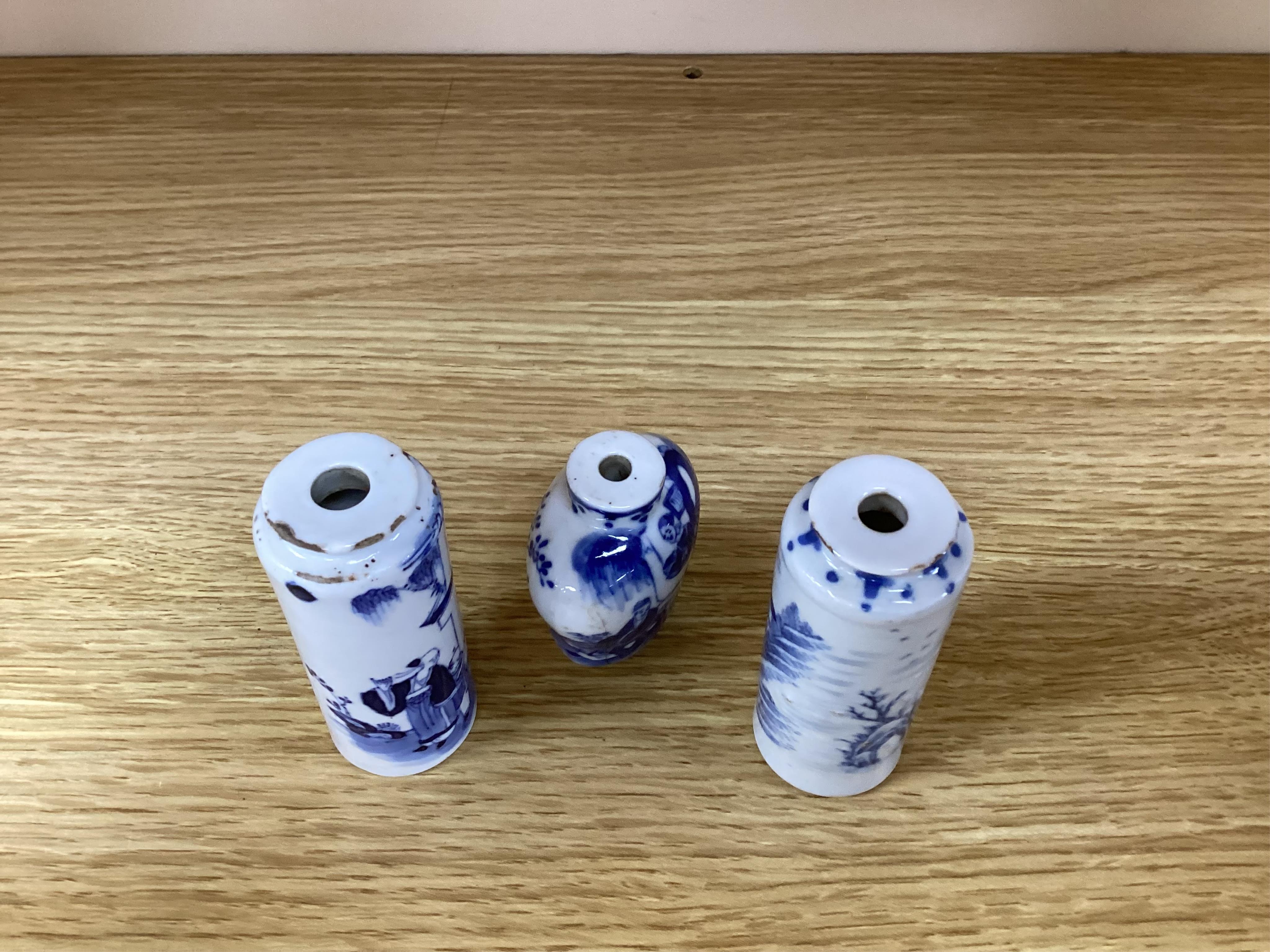 Three Chinese blue and white snuff bottles and three hardwood stands, largest 8cm high. Condition - poor to fair